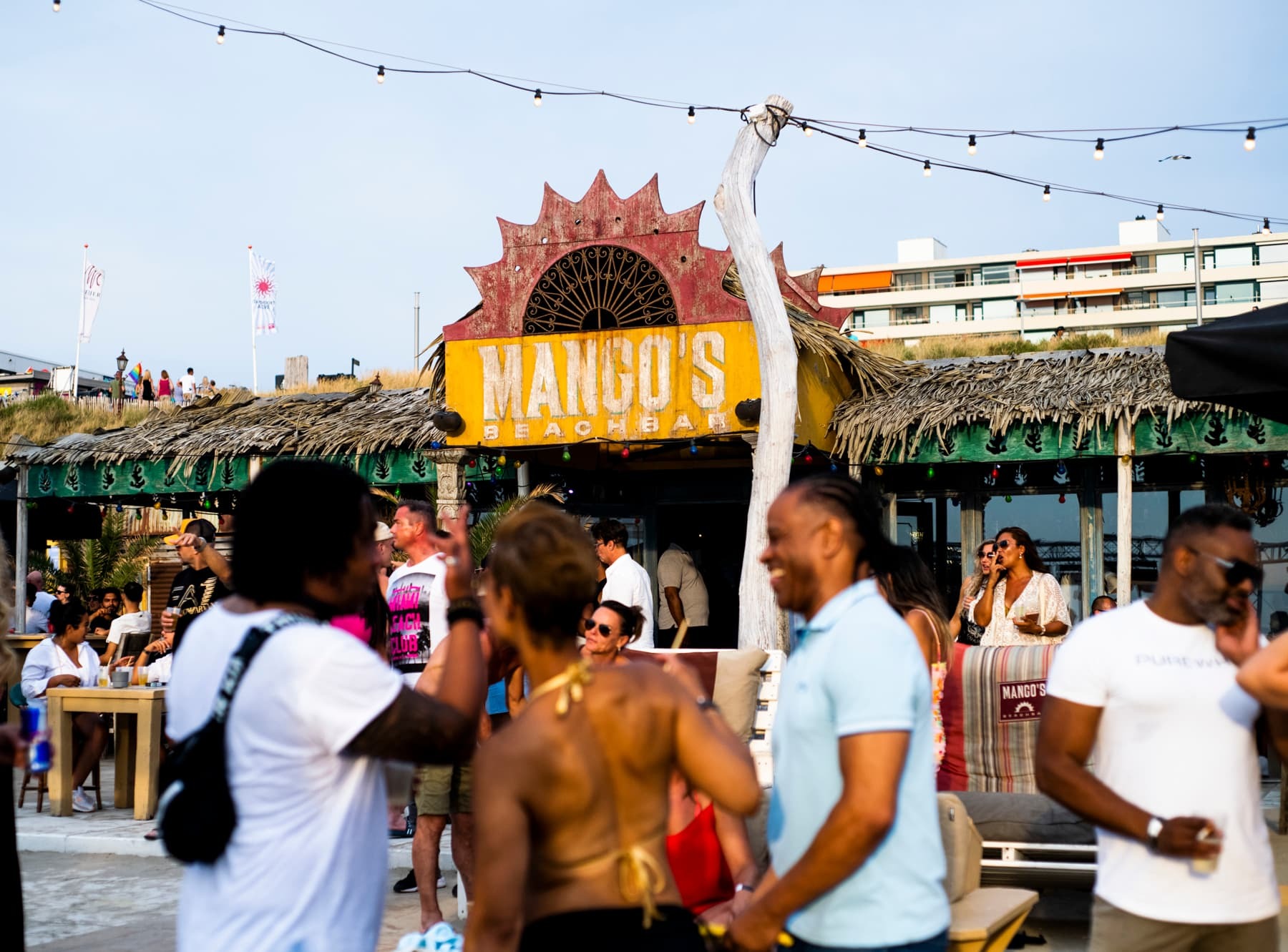 Een groep mensen op een strandfeest.