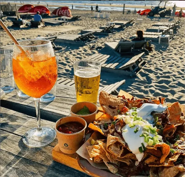 Nacho's met Aperol Spritz aan het strand.