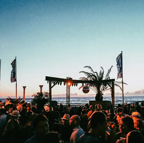 Feest op het strand met discobal bij de ondergaande zon.